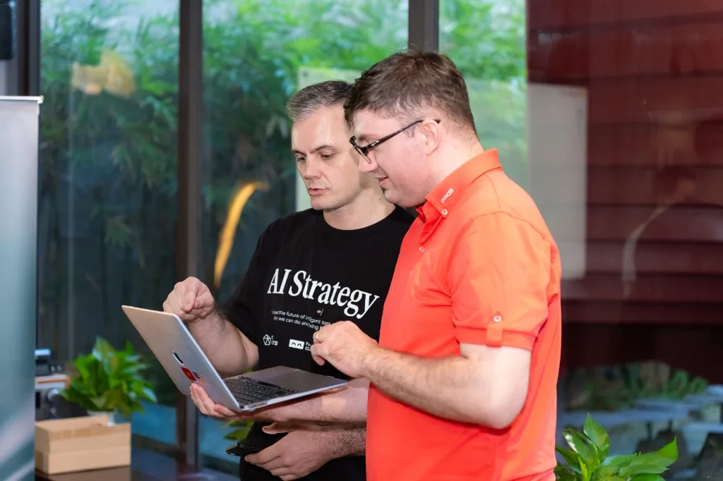 Looking over a laptop with someone at a workshop